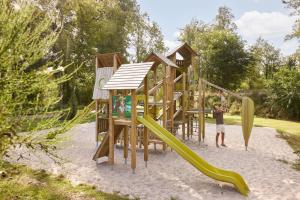a playground with a slide in the sand at RCN Vakantiepark de Noordster in Dwingeloo