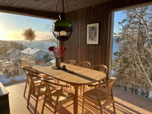a dining room table with chairs and a large window at Traditional Cabin In Modern Drøbak in Drøbak