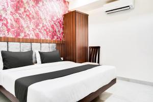 a bedroom with a large bed with a red wall at Super Collection O Panchvati Regency in Bhopal +30 photos