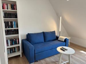 杜塞尔多夫Ruhiges und citynahes Dachgeschoss-Nest的客厅里的一张蓝色沙发和一张桌子 更多1张照片