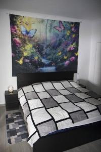 un letto in una stanza con un dipinto sul muro di House Villa Butterfly a São Roque do Faial