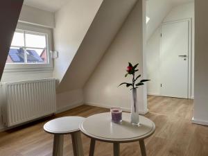 eine Vase mit einer Blume auf einem Tisch in einem Zimmer in der Unterkunft Ruhiges und citynahes Dachgeschoss-Nest in Düsseldorf