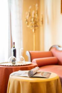 a table with a yellow table cloth and a bottle of wine at Apartment Manzoni Bardolino Center in Bardolino +31 photos