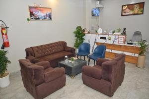 a waiting room with couches and chairs and a table at Hotel Sai Palace in Masodha
