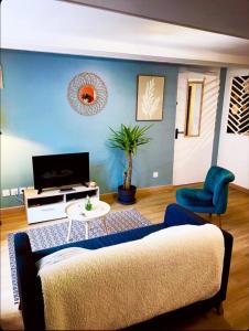 a living room with a couch and a table at L'atelier du Charme Dole Centre in Dole