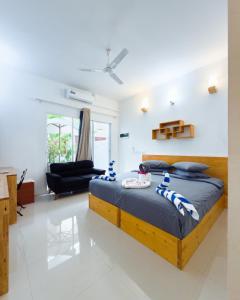a bedroom with a bed and a living room at The Wave Dhigurah in Dhigurah