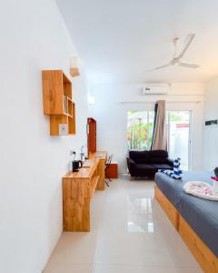 a bedroom with a bed and a living room at The Wave Dhigurah in Dhigurah