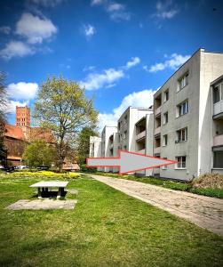 a bench in the grass in front of a building at Przy ZAMKU in Malbork +7 photos