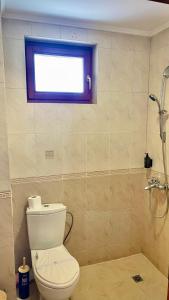 La salle de bains est pourvue de toilettes, d'une fenêtre et d'une douche. dans l'établissement Хотел Елит Релакс, à Devin