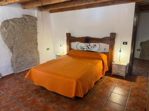 a bedroom with a bed with an orange blanket at Casa Lolita in El Río +10 photos