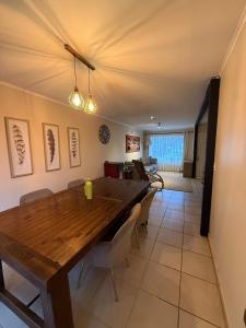 una sala da pranzo con tavolo e sedie in legno di Casa para 6 en Villarrica Jardín Floresta a Villarrica