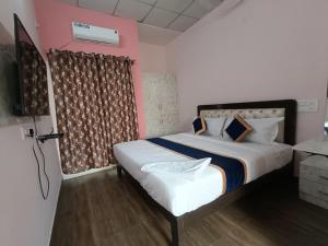 a bedroom with a bed and a television in it at White Rabbit Rooms in Bangalore +11 photos