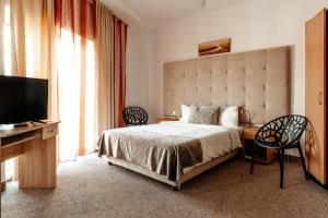 une chambre avec un lit et une télévision à écran plat dans l'établissement Hotel Strelitia, à Timişoara