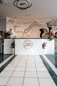 une pièce avec un comptoir orné de fleurs au mur dans l'établissement Hotel Strelitia, à Timişoara
