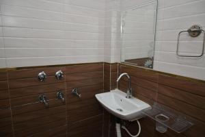 a bathroom with a sink and a mirror at Hotel Sai Palace in Masodha +20 photos