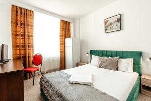 a hotel room with a bed and a desk at Hotel Strelitia in Timişoara