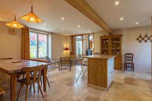 a kitchen and dining room with a table and chairs at L'Eco-logis du Clos Des Tilleuls in Molieres-Glaudaz