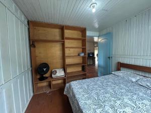 a bedroom with a bed and a wooden wall at Aluguel para Temporada, Praia da Gamboa, Garopaba SC in Garopaba