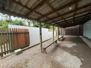 a patio with a bench sitting under a roof at Aluguel para Temporada, Praia da Gamboa, Garopaba SC in Garopaba +4 photos