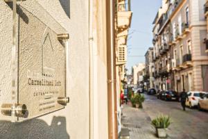 a building with a sign on the side of a street at Carmelitani Loft Catania Center in Catania