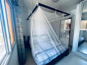 ein Bett mit einem Netz in einem Zimmer mit einem Fenster in der Unterkunft Appartement vue sur la mer Almadies Dakar "Résidence les embruns" in Dakar + 14 Fotos