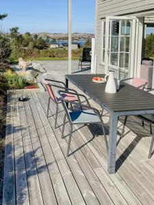 a patio with a table and chairs on a deck at Cozy Family Cabin Surrounded By Idyllic Islands in Fitjar