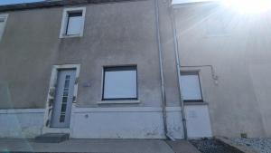 een gebouw met drie ramen en de zon die erop schijnt bij Le Petit Héros Gîte in Courlay