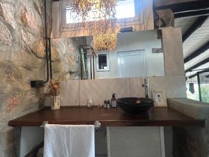 a kitchen counter with a sink and a mirror at suites en la montaña con propuesta de viñedo in La Cumbre