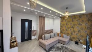 a living room with a couch and a wall at C-Home in Pécs