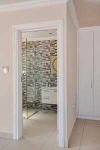 a hallway with a mirror and a brick wall at 4-bedroom in the center of the Southern Suburbs! in Cape Town +29 photos