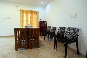 a row of chairs in a room with a table at MoStays in Pāppinisseri