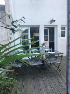 eine Terrasse mit einem Glastisch und Stühlen auf einer Terrasse in der Unterkunft La Saline in Le Palais