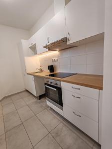 Star Apartments Brno C33# by Starbnb EU في برنو: مطبخ بدولاب بيضاء وموقد +6 صور
