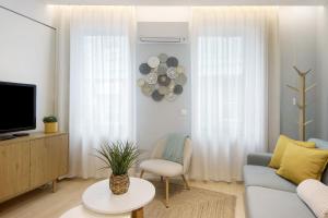 ein Wohnzimmer mit Sofa und Fernseher in der Unterkunft T1 Moliceiros Centro de Aveiro in Aveiro