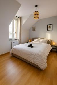 a bedroom with a large white bed and a wooden floor at Canal apartment ! Close to USON & Pont de Loire Nevers in Nevers