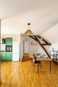 an attic kitchen and dining room with green cabinets and a table at Canal apartment ! Close to USON & Pont de Loire Nevers in Nevers