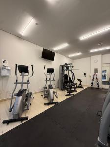 einen Fitnessraum mit mehreren Heimtrainern und einem Flachbild-TV in der Unterkunft Studio aconchegante, com lazer completo na serra in Araras Petropolis + 11 Fotos
