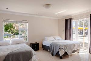 a bedroom with two beds and a window at 4-bedroom in the center of the Southern Suburbs! in Cape Town