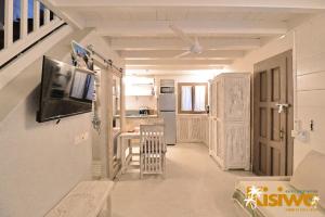 uma sala de estar com um sofá e uma TV na parede em Kisiwa Apartments Watamu - At Ascot Resort - em Watamu