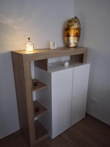 ein Holzregal mit einer Vase darüber in der Unterkunft A Casa di Lucia-Appartamento Deluxe in Piedimonte San Germano