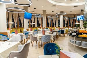 Hotel Orpheus - Casino and SPA في بامبوروفو: غرفة طعام مع طاولات وكراسي