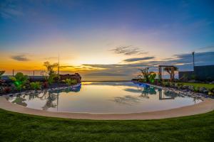 - une piscine dans un complexe avec un coucher de soleil en arrière-plan dans l'établissement Experiencia Habitación Burbuja con Jacuzzi Privado, Piscina y Vistas al Mar, à Guía de Isora