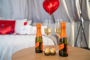 2 bouteilles de vin et 2 verres sur une table dans l'établissement Experiencia Habitación Burbuja con Jacuzzi Privado, Piscina y Vistas al Mar, à Guía de Isora