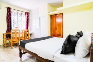 Un dormitorio con una cama, una mesa y una silla. en Hotel O Casa De Elevterio, en Goa