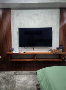 einen Flachbild-TV auf einem hölzernen Entertainment-Center in der Unterkunft Villa Arcadia in Los Baños