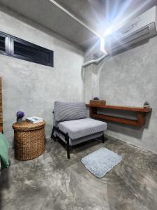 ein Wohnzimmer mit einem Stuhl und einer Klimaanlage in der Unterkunft Villa Arcadia in Los Baños