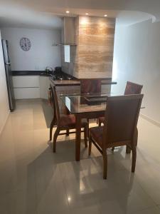 eine Küche mit Tisch und Stühlen und einem Herd in der Unterkunft Confortável Apartamento em Angra dos Reis in Angra dos Reis