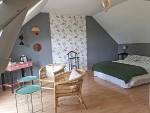 ein Schlafzimmer mit einem Bett und zwei Stühlen in der Unterkunft Ty Coz Breizh Chambres d'hôtes in Guidel