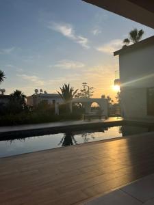 a sunset over a swimming pool in a house at Villa Leda - The Guest Wing in Paphos City