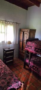 una camera da letto con due letti, un tavolo e una finestra di La Cañada a Colón